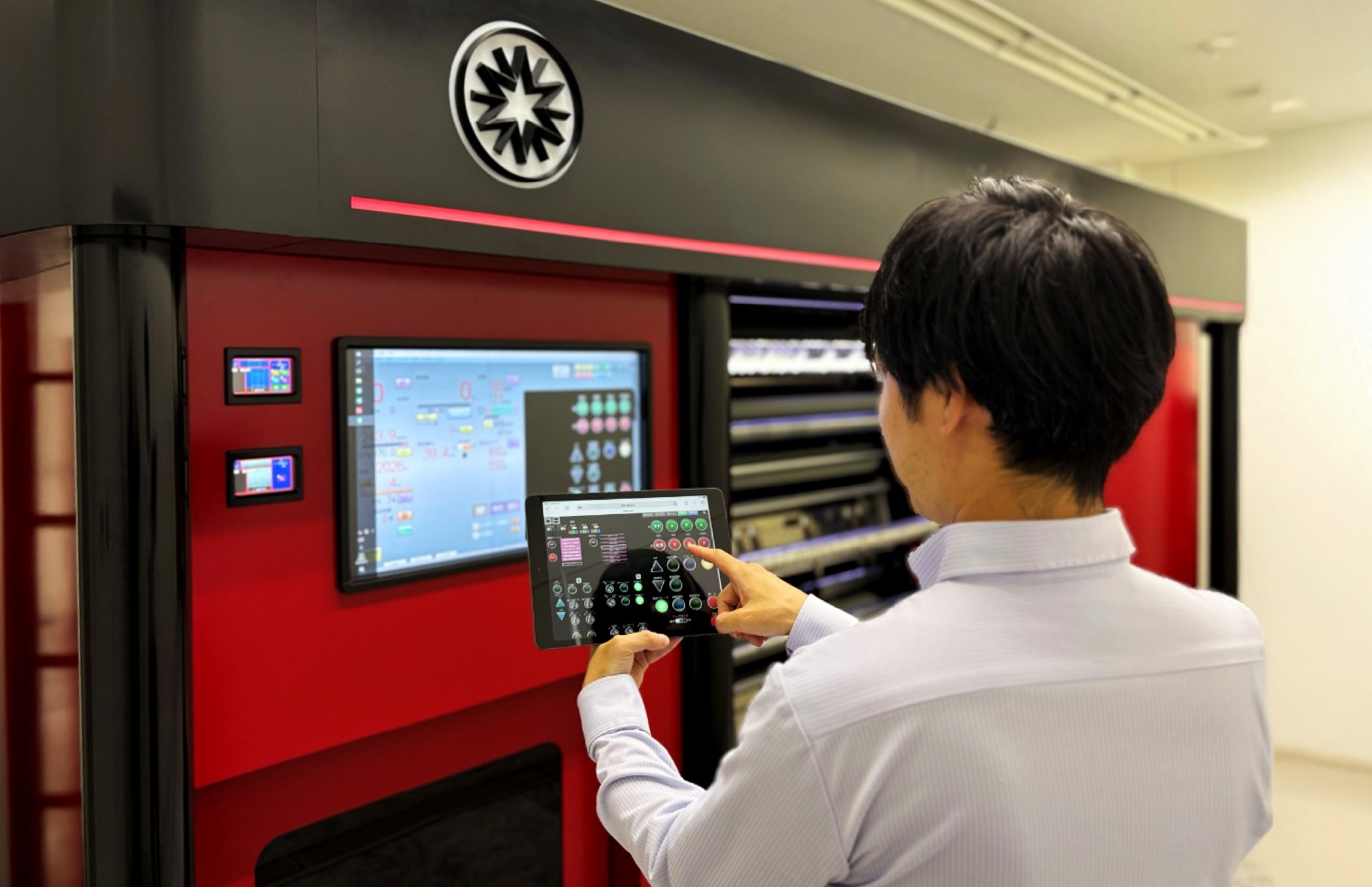 An employee operating a slitting machine with a tablet