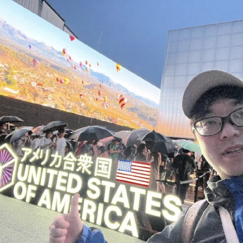 万博のアメリカ館前で自撮りする社員