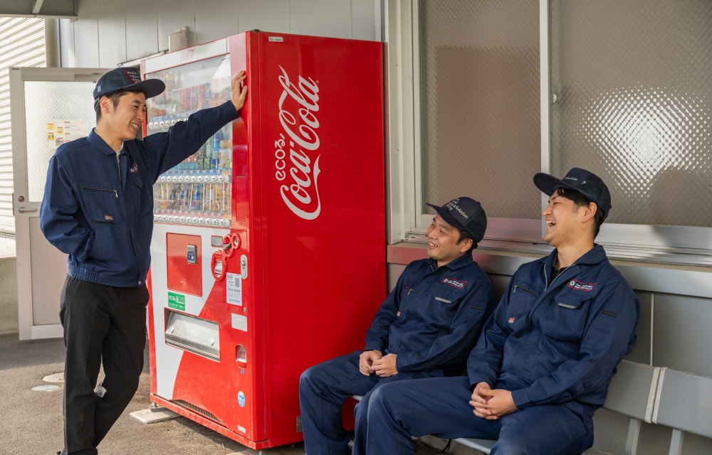 自動販売機の前のベンチで談笑する社員